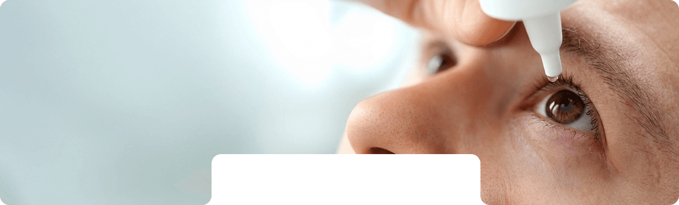 Eye drop being applied before laser vision correction